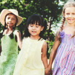 gritgroup - children holding hands outdoors smiling